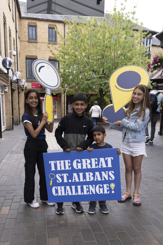 A group of young people holding a sign that says The Great St Albans Challenge..